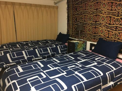 a bedroom with a bed with a blue and white comforter at Rumah Kyoto Yu in Kyoto