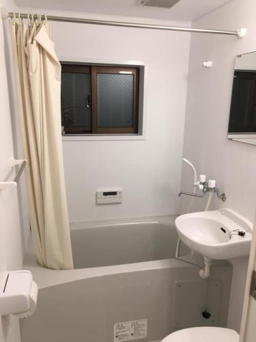 a white bathroom with a sink and a toilet at Rumah Kyoto Yu in Shimmachidōri