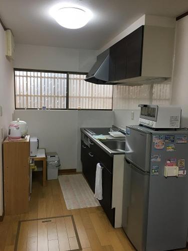 a kitchen with a refrigerator and a sink in it at Rumah Kyoto Yu in Shimmachidōri