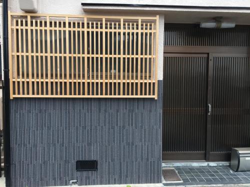 een gebouw met een houten poort en een deur bij Rumah Kyoto Yu in Shimmachidōri