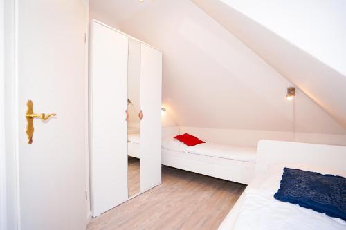 una piccola camera mansardata con letto e specchio di Ferienhaus Amanda a Grömitz