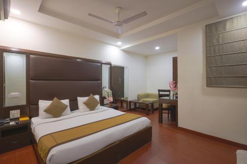 a bedroom with a bed and a desk and a chair at Hotel Haris MG Road Gurugram in Gurgaon