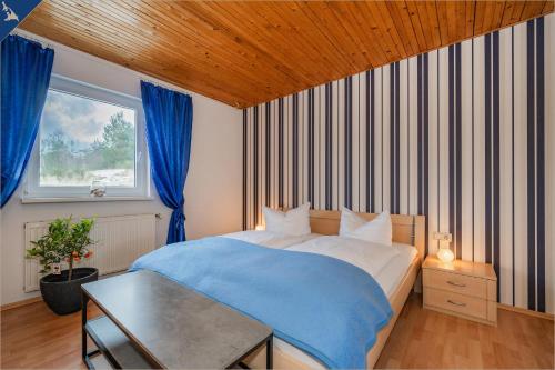 1 dormitorio con 1 cama con manta azul en Ferienhaus Olé FH Olé Wiesenblick Appartement, en Heringsdorf