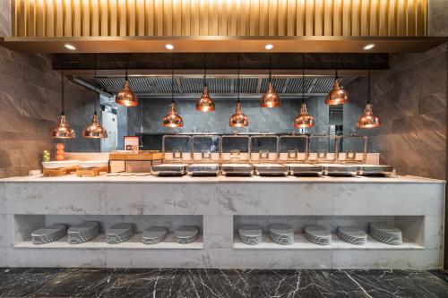 a kitchen with a counter with plates and lights at Layers Hotel Busan Hadan in Busan