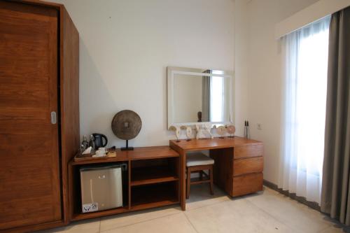a bathroom with a wooden desk with a mirror at Paripadi Private Villa and Sanctuary in Canggu