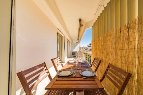 d'une longue table en bois avec des chaises sur le balcon. dans l'établissement Very nice one bedroom in the heart of Cannes, à Cannes