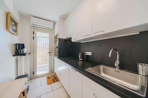 une cuisine avec des armoires blanches et un évier dans l'établissement Very nice one bedroom in the heart of Cannes, à Cannes