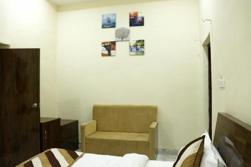 um quarto com uma cadeira, uma cama e uma parede em HOTEL KING EDWARD MEMORIAL em Ajmer