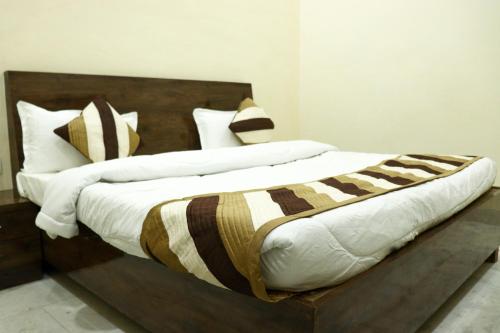 um quarto com uma cama grande e uma cabeceira em madeira em HOTEL KING EDWARD MEMORIAL em Ajmer