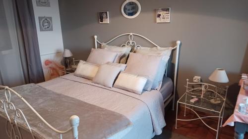 a bedroom with a bed with white pillows at La Tuiliere in Saint-Laurent-du-Var