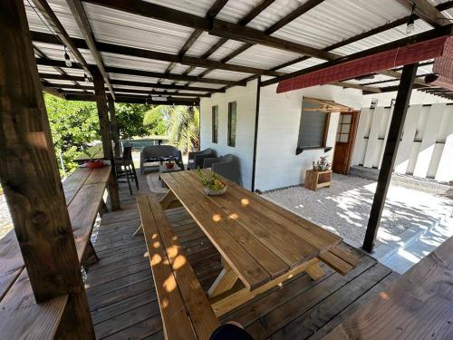 una terraza de madera con mesa y sillas. en Fare Mahai, en Avatoru