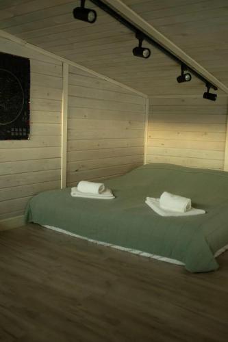 a room with a bed with two towels on it at Country House in Almaty