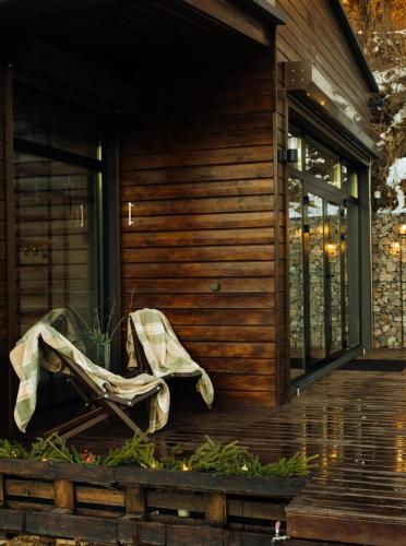 a chair sitting on the porch of a house at Country House in Almaty