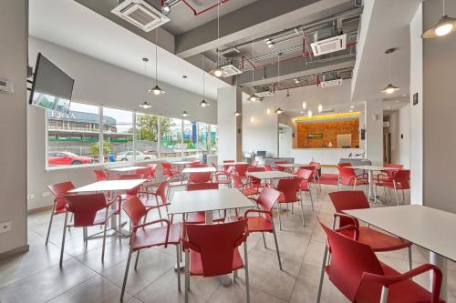a dining room with tables and red chairs at City Express Junior by Marriott Ciudad del Carmen in Ciudad del Carmen