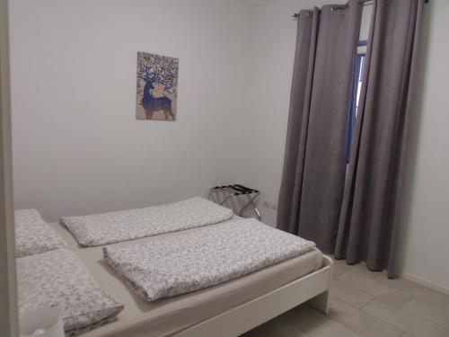 a bedroom with two beds and a picture on the wall at Apartaments and Rooms Claudia Augusta in Bolzano