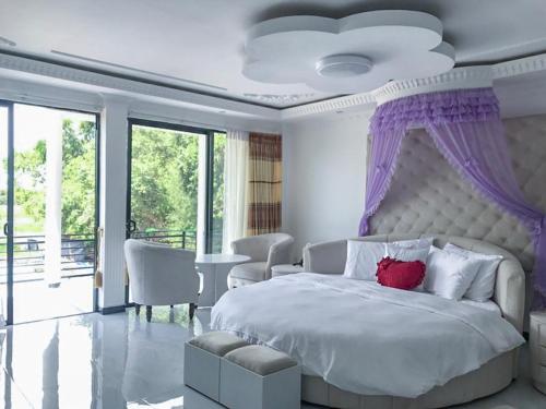 a white bedroom with a large bed with a large window at The Lion Kingdom Sigiriya in Sigiriya