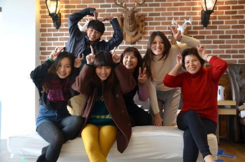 a group of people sitting on a bed with their hands up at Follow Me designed B&B in Dongshan