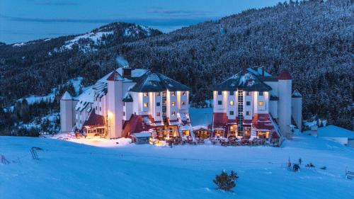 a large building in the snow at night at Monte Baia Uludağ - Full Board Plus in Uludag