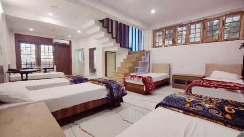 a bedroom with four beds and a stair case at Richhariya Nature's Retreat Homes in Jhānsi