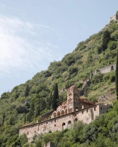 a building on the side of a mountain at HELLAS PALACE ROOMS balcony in Sparti
