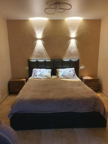a bedroom with a large bed with lights on the wall at Prima home 