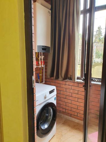 a washing machine in a room with a window at Prima home 
