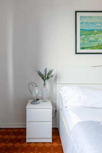 a bedroom with a white bed and a white nightstand at LA MAR Apartment Spinea in Spinea