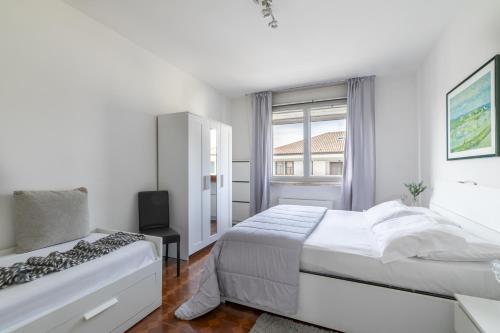 a white bedroom with a bed and a window at LA MAR Apartment Spinea in Spinea