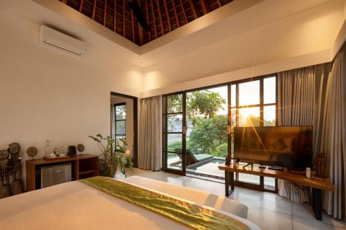 a bedroom with a large bed and a large window at Paripadi Private Villa and Sanctuary in Canggu