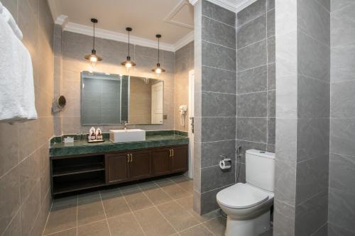 een badkamer met een toilet, een wastafel en een spiegel bij Cambana Poipet Hotel in Krong Poi Pet
