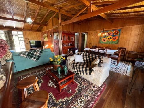 a living room with a couch and a table at Recanto Habacuque in Campos do Jordão