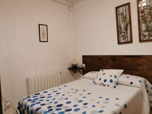 a bedroom with a bed with a blue and white comforter at Casa Rural l'Avia Tica in Benisuera