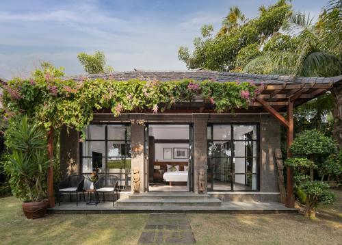 a garden room with a pergola and plants at Paripadi Private Villa and Sanctuary in Canggu