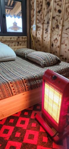 eine rote Lampe auf dem Boden neben einem Bett in der Unterkunft Homestay Huyền Thoại Cao Nguyên Đá 