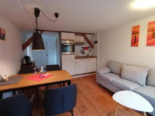 ein Wohnzimmer mit einem Tisch und einem Sofa in der Unterkunft Ferienwohnungen Dornröschen in Weißensberg