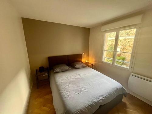 - une chambre avec un lit et une fenêtre dans l'établissement Le Sept avec parking, transfert, à Vaires-sur-Marne