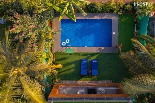 una vista aérea de una piscina con palmeras en Ekostay Gold- Salt Water Villa I Sea View I 200 meters from Beach en Candolim