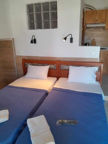 two beds sitting next to each other in a room at "Village Aris" Sevasti Symi Studios in Symi