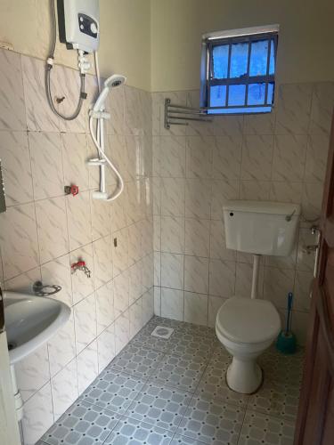ein Bad mit einem WC, einer Dusche und einem Waschbecken in der Unterkunft Suba Motel in Kihihi