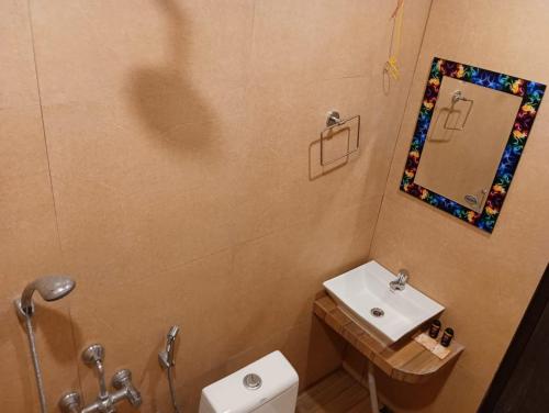 ein Badezimmer mit Waschbecken, Spiegel und Toilette in der Unterkunft Royal Villa Beach Resort in Havelock Island