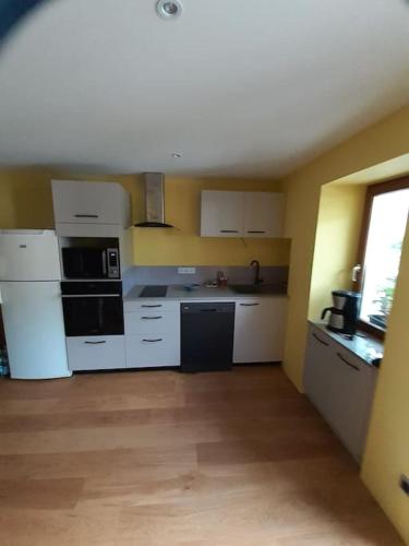 - une cuisine avec des appareils électroménagers blancs dans l'établissement Maison Cosy, cœur de village, à École