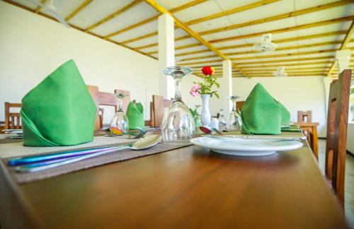 a wooden table with green napkins on top of it at The Lion Kingdom Sigiriya in Sigiriya
