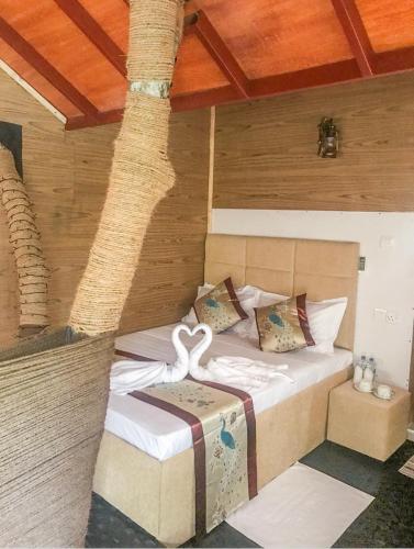 a bed in a room with a palm tree at The Lion Kingdom Sigiriya in Sigiriya