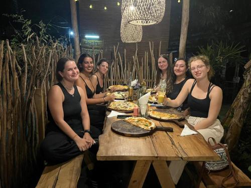 a group of women sitting at a table eating pizza at Cycling Backpacker Hostel in Unawatuna