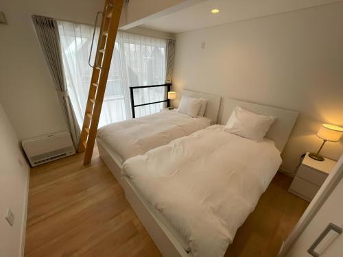 two beds in a small room with a ladder at 【ペット可】Niseko STREAM Villas in Rankoshi