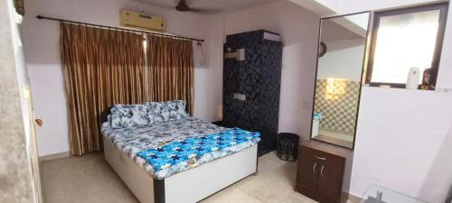 małą sypialnię z łóżkiem i lustrem w obiekcie Dreamland- The flat of your dreams/ Entire 1bhk Apartment w Bombaju