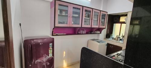 a kitchen with pink cabinets and a refrigerator at Dreamland- The flat of your dreams/ Entire 1bhk Apartment in Mumbai