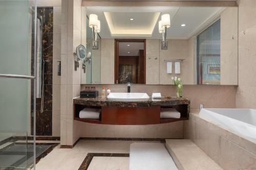 a bathroom with a sink and a tub and a shower at Crowne Plaza Tianjin Binhai Center, an IHG Hotel in Binhai