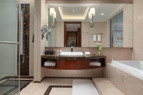 ein Badezimmer mit einem Waschbecken, einer Badewanne und einer Dusche in der Unterkunft Crowne Plaza Tianjin Binhai Center, an IHG Hotel in Binhai