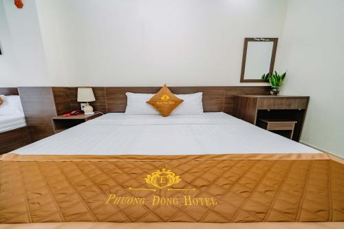 a bedroom with a bed with a sign that reads bronze dance hotel at Phuong Dong Hotel in Cat Ba